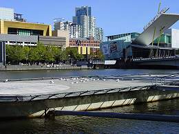 Melbourne Exhibition Centre and Crown Casino seen across the Yarra River from Batman Park, with helipad in the foreground. Photograph by Ali Kayn, 2005; 260x195